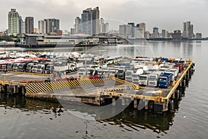 Trucks, buses and Skyline of tall buildings at South Harbor in Manila, Philippines