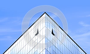 Light reflection on surface of modern glass office building against blue sky