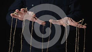 Manipulator hands with ropes on fingers. Black background