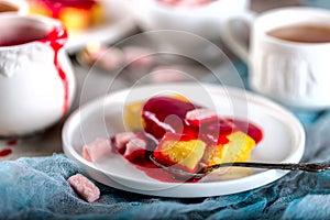 Manne cake with raspberry jam on a white plate. Tea party.