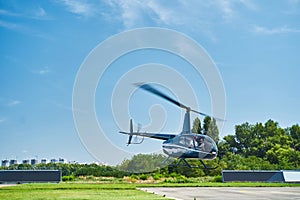 Manned helicopter taking off from landing pad at heliport