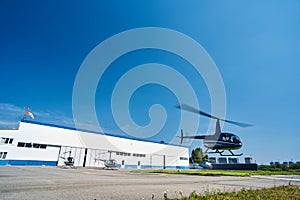 Manned rotary-wing aircraft flying over landing pad