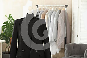 Mannequin with black jacket in tailor shop, space for text