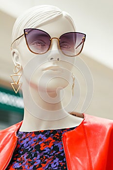 Mannequin face. Bright portrait of female beautiful dummy in purple sunglasses with earrings