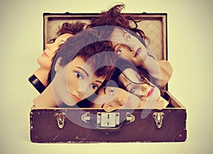 Mannequin heads in an old suitcase