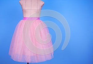 Mannequin in pink princess skirt on blue background