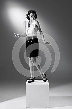 Portrait of beautiful woman in character of famous fashion designer posing in stylish classic suit. Black and white