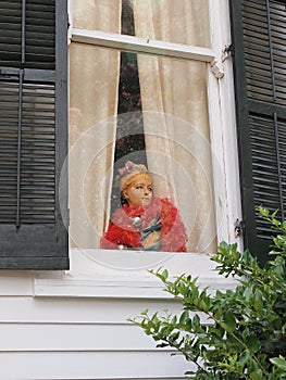 Mannequin sitting in a window of a home