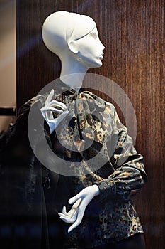 Mannequin standing in store window display of womens casual clothing shop