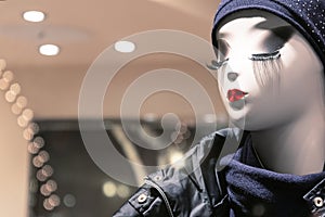 Mannequin in the store with red lips, white skin and long eyelashes