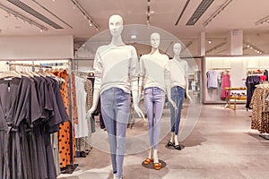 Mannequins in jeans and white jumpers in a virgin clothing store. Baner. Sale season