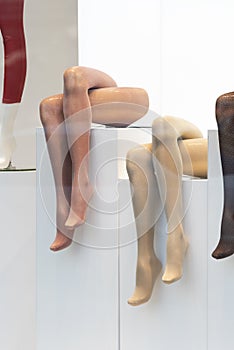 Mannequins legs in shop window. Tights. Hosiery shop. Vertical frame