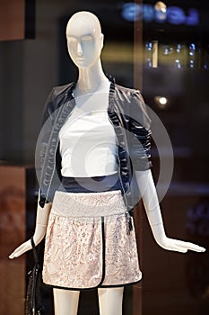 Mannequins standing in store window display of womens casual clothing shop