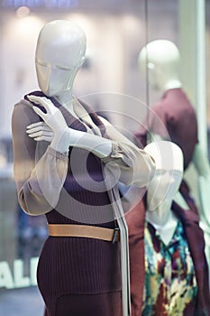 Mannequins standing in store window display of womens casual clothing shop