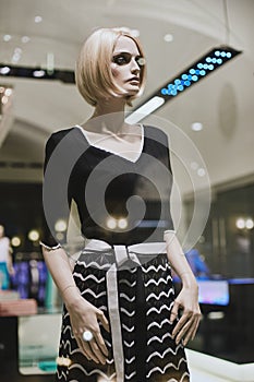 Mannequins standing in store window display of womens casual clothing shop in shopping mall