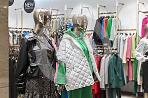 Mannequins in the window of a women`s clothing store. Fashion & Style. Advertising of the new collection