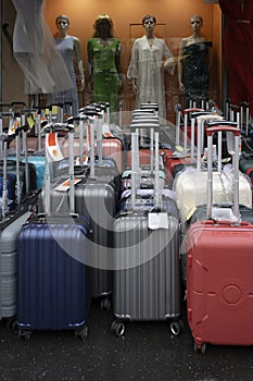 Mannequins in the windows and street display of luggage and bags for sale