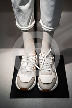 Mannequins in a women`s store in store window show autumn winter collection shoes. Standing dummies show casual style