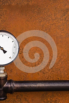 Manometer part and part of a black pipe on a dark brown rusty background design of an old factory with copy space