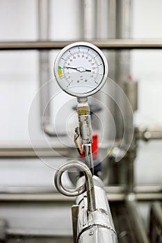 Manometer on pipe in milk production machine