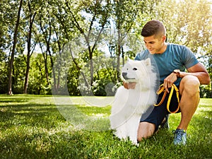 Mans best friend. a handsome young man walking his dog in the park.