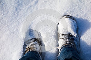 Mans feet buried in snow.
