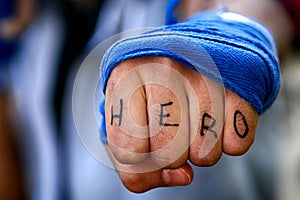 Mans fist punching with hero letter on the fingers water. Human power force