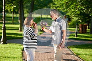 Mans giving flowers to his wife.