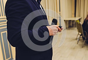Mans hand holding a microphone conducting an interview.