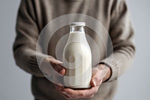 Mans Hand Holds Bottle Of Milk Against White Background. Generative AI