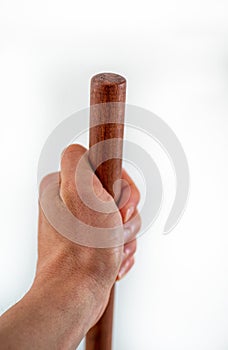 Mans hand holds brown wooden haft on white background