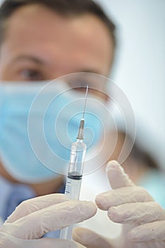 Mans hand in medical glove with syringe photo