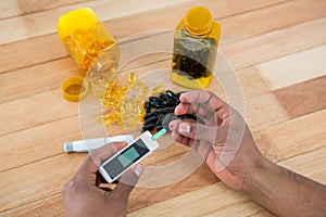 Mans hand testing blood sugar with glucometer