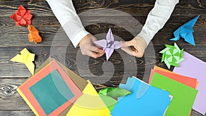 Mans hands doing origami flower.