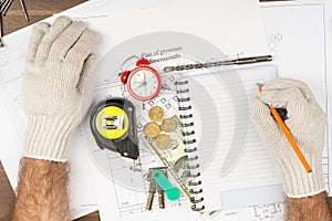 Mans hands in gloves writing and keys