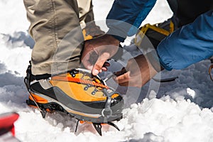 The mans hands helps you set up and dress alpinist crampons