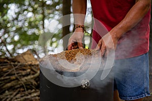 mans hands placing a large beef brisket on a smoker