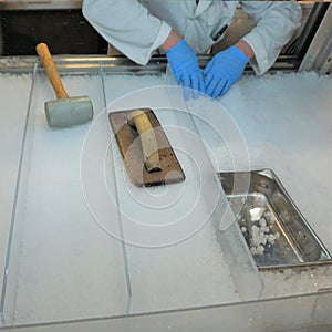 Mans hands prep ice for fish market sale