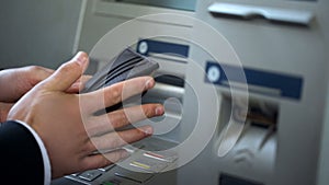Mans hands putting euros in wallet, cash withdrawn from ATM, travelling abroad