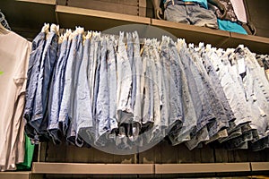 Mans wear - different types of blue jeans on hangers