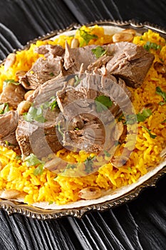 Mansaf is a traditional Arabic lamb dish that is cooked in yogurt sauce with rice closeup in the plate. Vertical photo