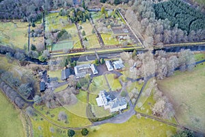 Mansion and private tennis court in real estate grounds aerial view from above