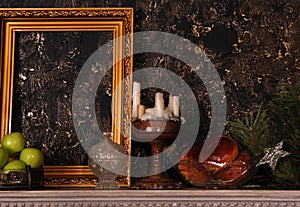 Mantelpiece with frame, apples, cakes, candlestick and pine branch