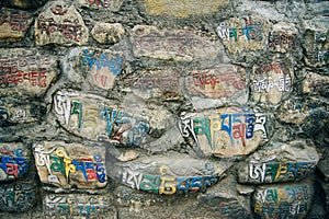 The mantra Om Mani Padme Hum painted on mani stones or rocks. Nepal, Kathmandu - august, 2018.