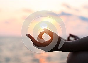 Mantra yoga meditation practice with silhouette of woman in lotus pose having peaceful mind relaxation on the beach