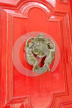 Manual brass doorbell in the form of two girls holding a coat of arms