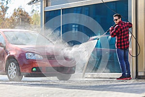 Manual car wash with pressurized water in car wash outside.Summe Washing. Cleaning Car Using High Pressure Water.