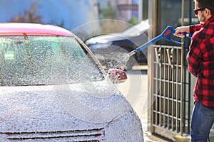 Manual car wash with pressurized water in car wash outside.Summe Washing. Cleaning Car Using High Pressure Water.