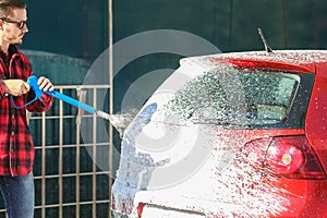 Manual car wash with pressurized water in car wash outside.Summe Washing. Cleaning Car Using High Pressure Water.