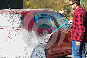 Manual car wash with pressurized water in car wash outside.Summe Washing. Cleaning Car Using High Pressure Water.